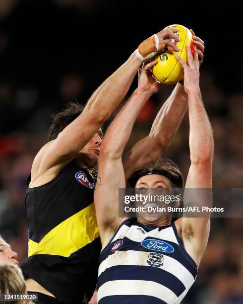 Robbie Tarrant of the Tigers and Jack Henry of the Cats compete for the ball during the 2022 AFL Round 15 match between the Geelong Cats and the...