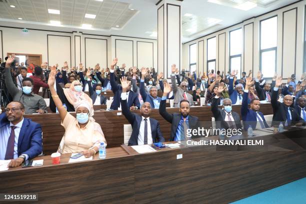 Somali MPs raise their hands during the election of the new Prime Minister in Mogadishu on June 25, 2022. - Somalia's parliament on Saturday...
