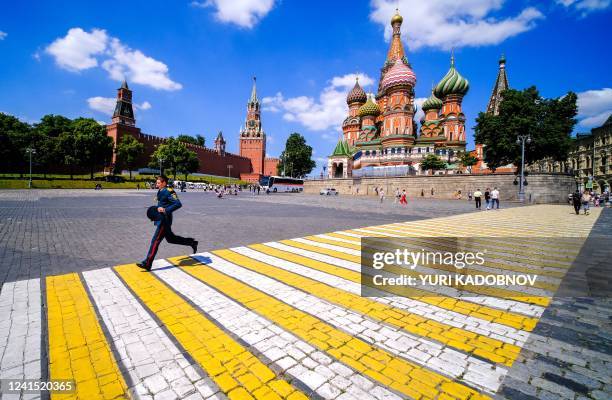 Russian officer crosses the square in front of Saint Basil's Cathedral near The Kremlin in Moscow, on June 25, 2022.