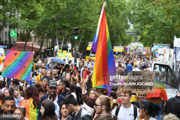 Participants wave flags and hold banners as they march during the annual Pride Parade in Paris on June 25, 2022. The Inter-LGBT association who is...