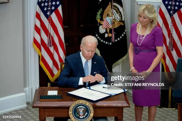 First Lady Jill Biden looks on as US President Joe Biden signs the Bipartisan Safer Communities Act into law, in the Roosevelt Room of the White...