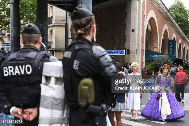 Two participants walk in front of French Gendarmes and members of the BRAVO, a part of the "Compagnies de Securisation et d'Intervention" during the...