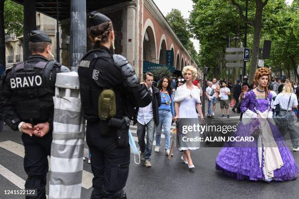 Two participants walk in front of French Gendarmes and members of the BRAVO, a part of the "Compagnies de Securisation et d'Intervention" during the...