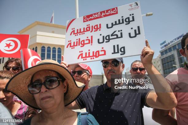 Supporters of the Free Destourian Party hold placards and flags of Tunisia during a demonstration held outside the building of the embassy of the...