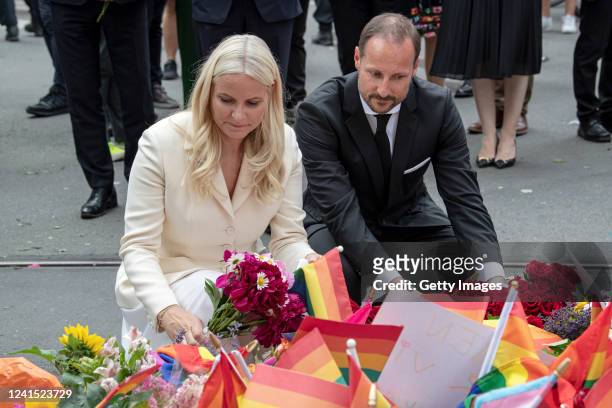 Crown Princess Mette-Marit of Norway and Crown Prince Haakon of Norway kneel to read tributes at a makeshift memorial on June 25, 2022 in Oslo,...