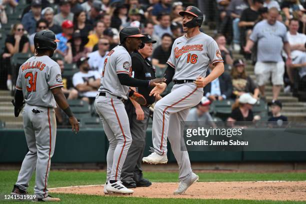 Trey Mancini of the Baltimore Orioles celebrates with Jorge Mateo and Cedric Mullins after scoring a run in the seventh inning against the Chicago...
