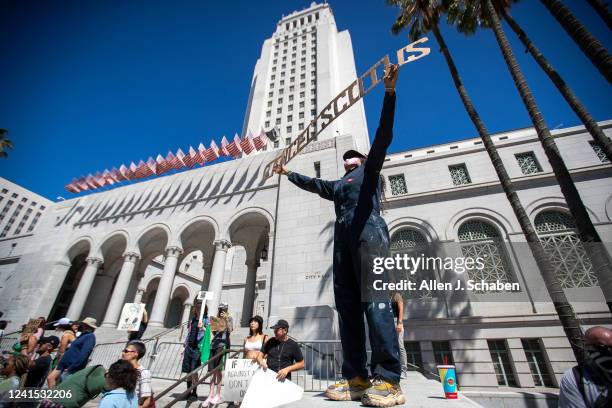 Los Angeles, CA Chandrika Metivier, of Houston, Texas, stands high on Los Angeles City Hall steps holding a sign reading CANCEL SCOTUS during one of...