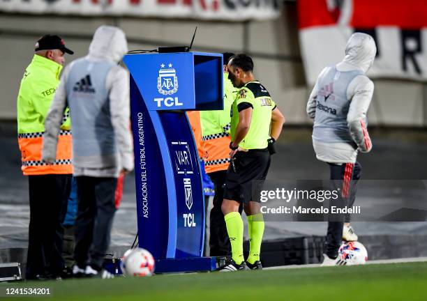 Referee Dario Herrera checks the VAR during a match between River Plate and Lanus as part of Liga Profesional 2022 at Estadio Monumental Antonio...