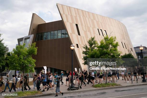 Protesters march past the National Center for Civil and Human Rights during a protest against the Supreme Court's ruling in the Dobbs v Jackson...