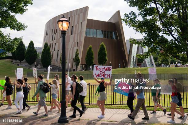 Protesters march past the National Center for Civil and Human Rights during a protest against the Supreme Court's ruling in the Dobbs v Jackson...