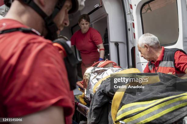 Female survivor is wheeled to an ambulance at the scene of a residential building following explosions in a neighborhood in north of Kyiv, Ukraine,...