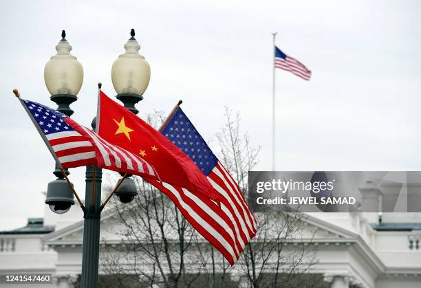 Lamp post is adorned with a Chinese national flag in between two US flags in front of the White House in Washington, DC, on January 17, 2011 previous...