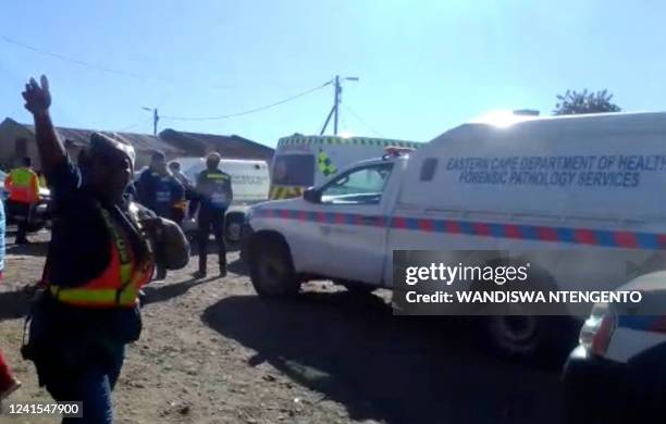 In this videograb taken from an AFP reporter, a police officer gestures at members of the press as vehicles from the pathology services are seen...