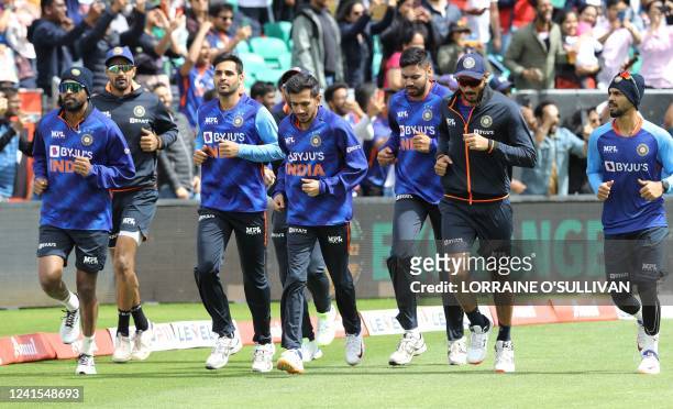Indian players warm up ahead of the Twenty20 International cricket match between Ireland and India at Malahide cricket club, in Dublin on June 26,...