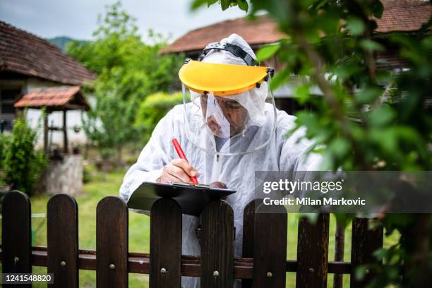 the farmer controls the yield of fruit and writes data useful for further maintenance work - pest stock pictures, royalty-free photos & images