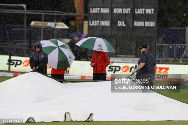 Groundstaff position the covers as rain delays the start of play in the Twenty20 International cricket match between Ireland and India at Malahide...