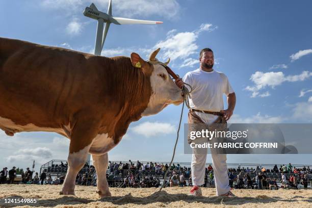 Florian Gnaegi poses with his prize "Stefano" after winning the final match of the Bernese Jura Swiss Wrestling Festival that celebrates the 100...
