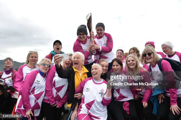 Batonbearers the Hiking Hens hold the Queens Baton as they pose for a selfie picture with Lady Mary Peters during the Birmingham 2022 Queen's Baton...