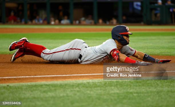 Luis Garcia of the Washington Nationals slides into third base after hitting triple against the Texas Rangers during the fifth inning at Globe Life...