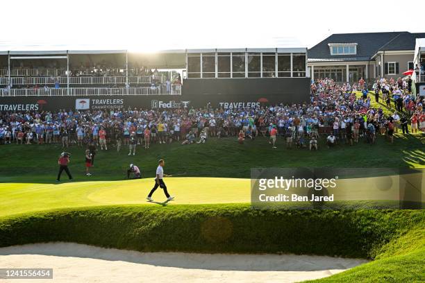 Xander Schauffele raises his putter while walking onto the 18th green during the final round of the Travelers Championship at TPC River Highlands on...