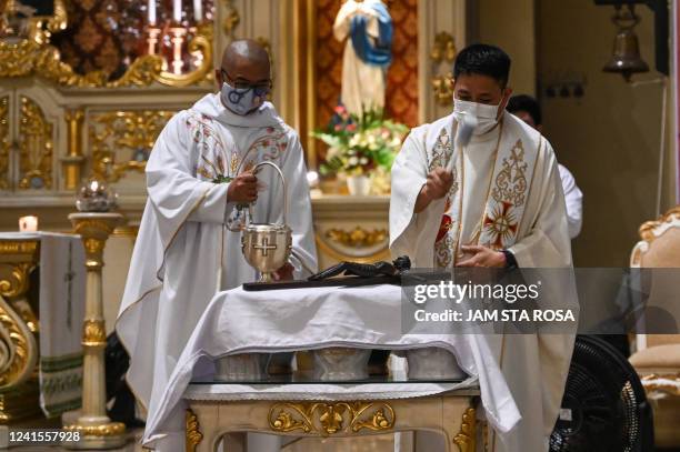 This photo taken on June 20, 2022 shows priests blessing urns containing the ashes of exhumed victims from the government's drug war during a...