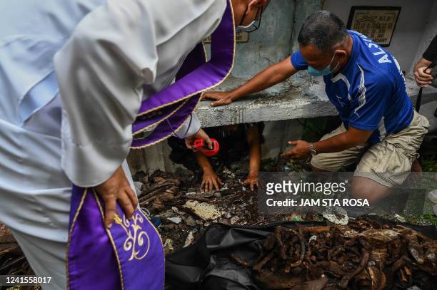 This photo taken on June 10, 2022 shows cemetery staff working to exhume the remains of drug war victims, at Tala Cemetery in Caloocan, Metro Manila....