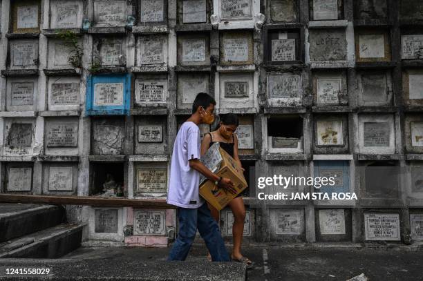 This photo taken on June 10, 2022 shows relatives of a victim of the government's drug war carrying a box containing the remains after they were...