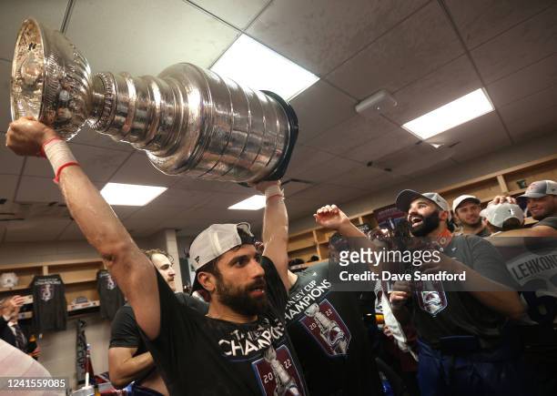 Andrew Cogliano of the Colorado Avalanche hoists the Stanley Cup in the locker room after Game Six of the 2022 Stanley Cup Final at Amalie Arena on...