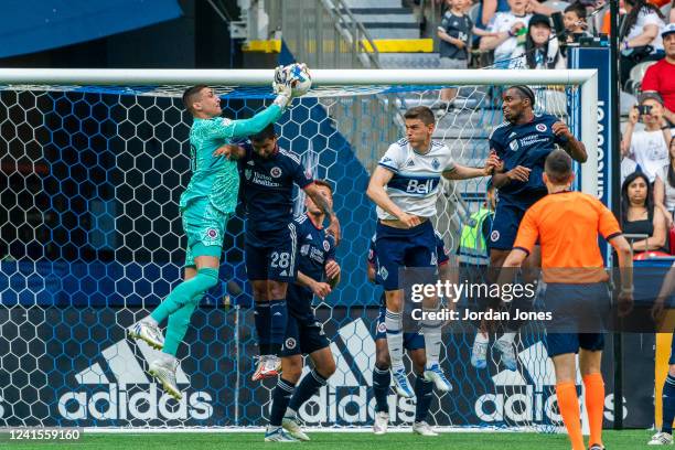 Djordje Petrovic of the New England Revolution catches the ball off his teammate A.J. DeLaGarza head during the game between Vancouver Whitecaps and...