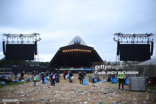 Festivalgoers help in cleaning up the venue at the end of the Glastonbury festival near the village of Pilton in Somerset, southwest England, on June...
