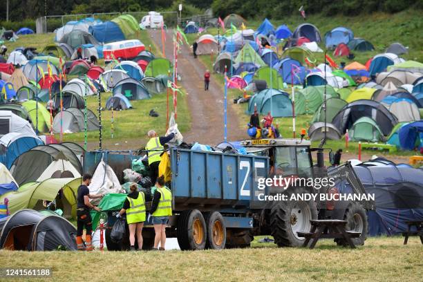 Cleaners load garbage bags onto a truck as they clean up the venue at the end of the Glastonbury festival near the village of Pilton in Somerset,...