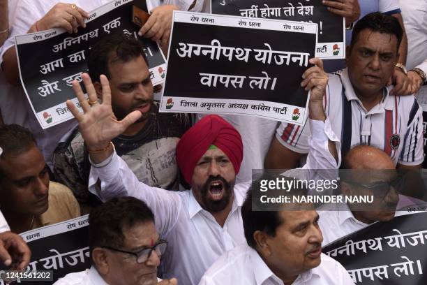 India's Congress party leaders and workers hold placards as they shout slogans against India's Prime Minister Narendra Modi during a protest against...