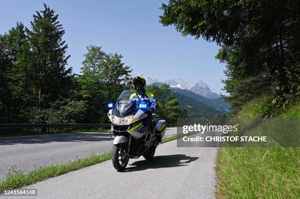 Police motorcycle leads as protesters ride bycicles during a demonstration against the G7 Summit, on June 27, 2022 near Klais, southern Germany, as...