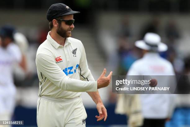 New Zealand's captain Kane Williamson passes the ball to New Zealand's Tim Southee during play on day 5 of the third cricket Test match between...
