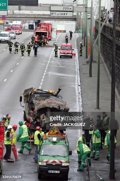 Des employés "des Services de la propreté" de Paris nettoient la chaussée suite à un accident impliquant une camionnette transportant des bouteilles...