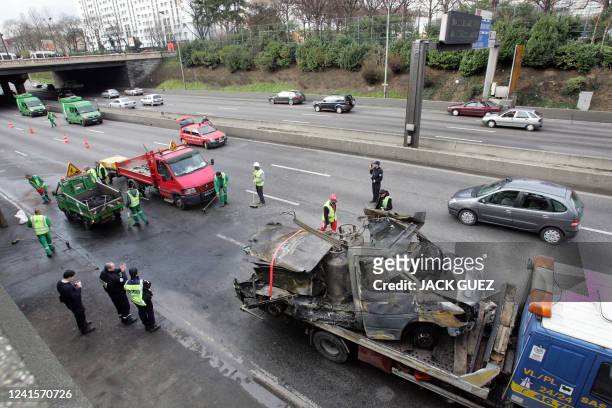 Des employés "des Services de la propreté" de Paris nettoient la chaussée suite à un accident impliquant une camionnette transportant des bouteilles...