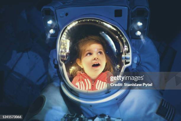 girl inside the astronaut suit - curiosity stock-fotos und bilder