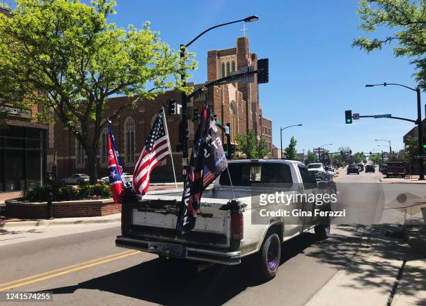 Vehicle passes through downtown with an Ole Miss flag, an American flag and a Trump flag flying in the back on June 10, 2022 in Casper, Wyoming. The...