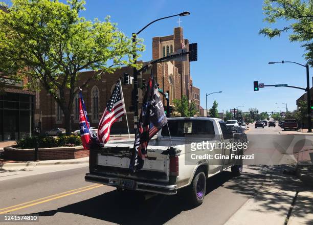Vehicle passes through downtown with an Ole Miss flag, an American flag and a Trump flag flying in the back on June 10, 2022 in Casper, Wyoming. The...