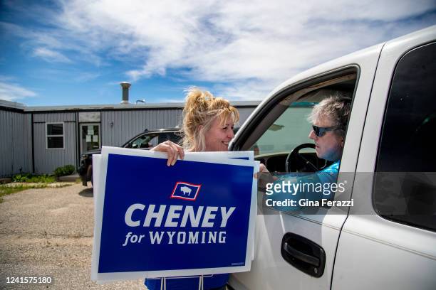 Liz Cheney political director Amy Womack gives resident Neal Hibschweiler a Cheney For Wyoming sign for his front lawn on June 10, 2022 in Casper,...