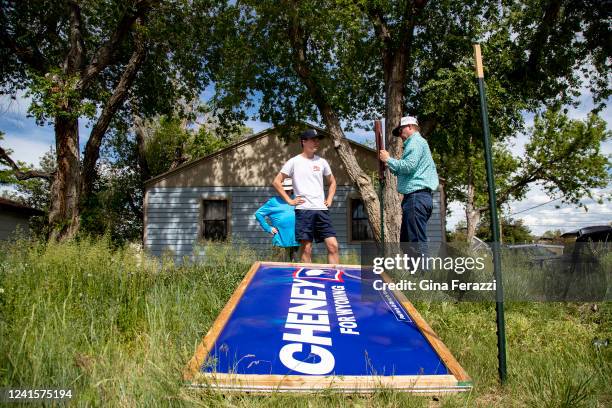 Liz Cheney campaign workers Elijah True, right, and his brother Rand True, middle, put up a large Cheney For Wyoming sign in the front yard of Neal...