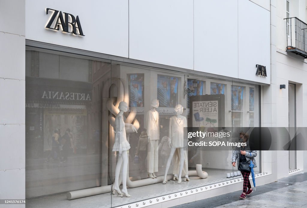 A pedestrian walks past the Spanish multinational clothing...