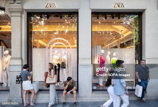Pedestrians walk past the Spanish multinational clothing design retail company by Inditex, Zara, a store in Spain.