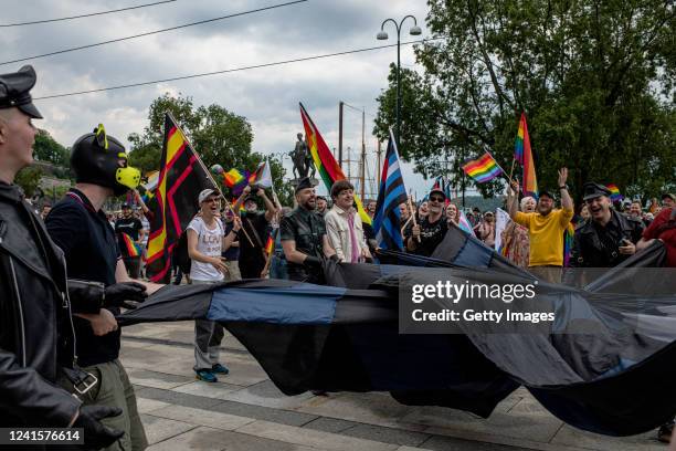 People running with a large flag in front of the city hall on June 27, 2022 in Oslo, Norway. Early on Saturday, a man fatally shot two people and...