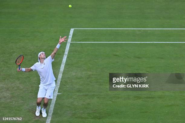 Player John Isner serves to France's Enzo Couacaud during their men's singles tennis match on the first day of the 2022 Wimbledon Championships at...