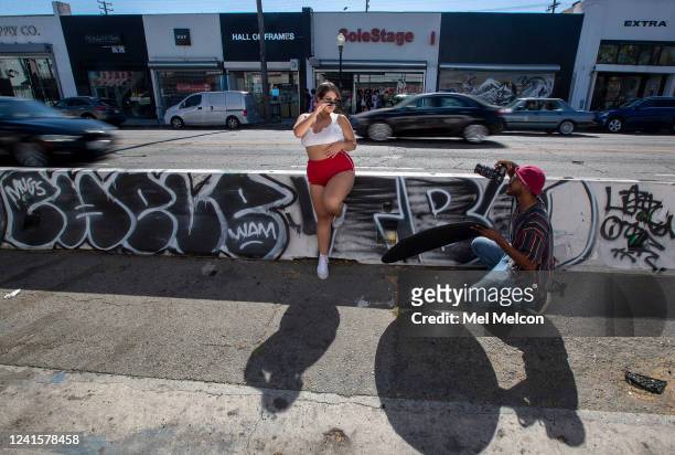 Kemani Stylzz right, uses a reflector to create a nice lighting effect while photographing Karen Rodriguez on Fairfax Ave. In Los Angeles between...