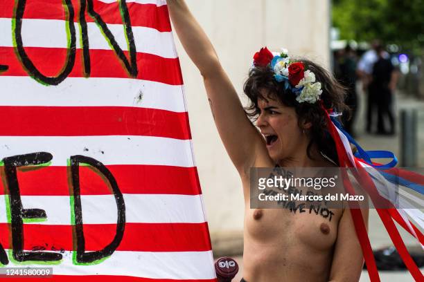Activist of feminist group FEMEN protesting bare-chested in front of the US Embassy. Activists are protesting with messages painted on their chests...