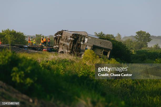 Railroad workers work the scene where an Amtrak train derailed on June 27, 2022 in Mendon, Missouri. The train, traveling from Los Angeles to...