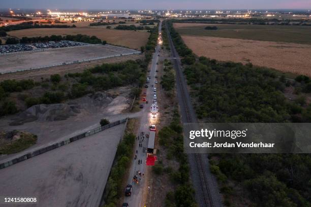 In this aerial view, members of law enforcement investigate a tractor trailer on June 27, 2022 in San Antonio, Texas. According to reports, at least...