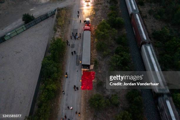 In this aerial view, members of law enforcement investigate a tractor trailer on June 27, 2022 in San Antonio, Texas. According to reports, at least...